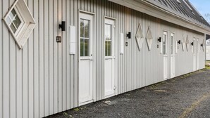 Una hilera de edificios blancos con números en las puertas, probablemente un hotel o residencia estudiantil.