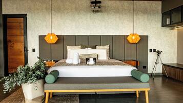 A modern bedroom with a large bed, wooden headboard, and two pendant lights.