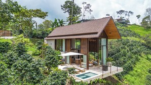 Een modern huis met een groot raam, een zwembad en een terras.