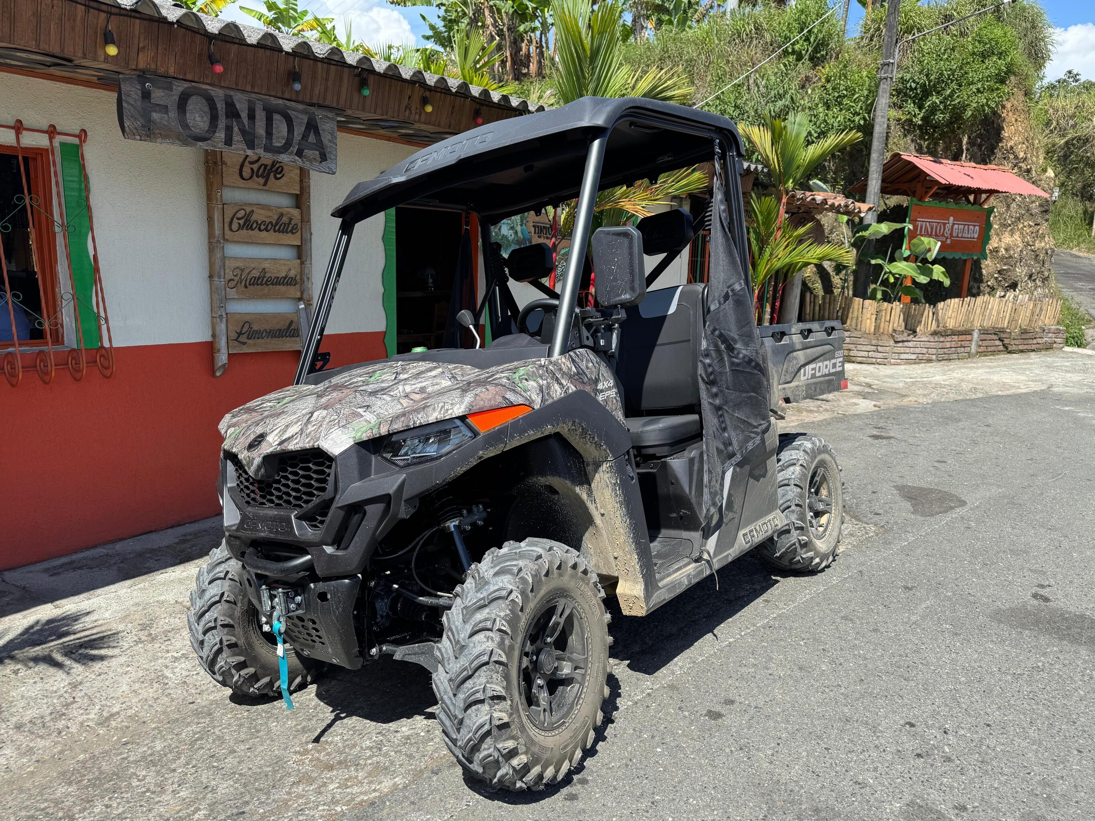 Un cuatrimoto estacionado frente a un edificio con un letrero que dice "FONDA Cafe".