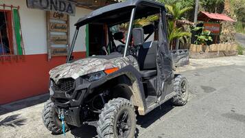 Un cuatrimoto estacionado frente a un edificio con un letrero que dice "FONDA Cafe".