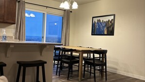 Et moderne køkken med spiseplads, et stort vindue med udsigt og et billede på væggen.
