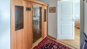 A hallway with a wooden wardrobe, a glass door, a patterned rug, and a white door leading to another room. - 3 bedroom cozy apartment in Gålå (Gålå)