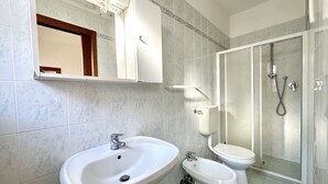 A bathroom with a large sink, a toilet, and a shower enclosure.