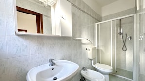 A bathroom with a large sink, a toilet, and a shower enclosure. - Villa Bianca 5 - Carraro Immobiliare Jesolo (Lido di Jesolo)