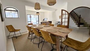 A dining area with a wooden table, brown chairs, and woven placemats.
