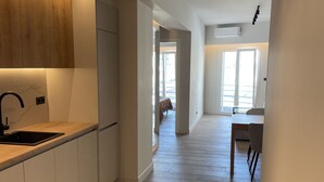 A modern kitchen with wooden cabinets, a black countertop, and a sink. - Athens City Chic apartment  in Petralona,with 2 double bedrooms and 2 bathrooms (Athens)