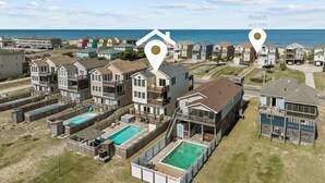 A coastal residential area with multiple two-story houses, a swimming pool, and beach access. - 5711-OBX TA SEA - Semi-Oceanfront Escape w/ Pool & Hot Tub (Nags Head)