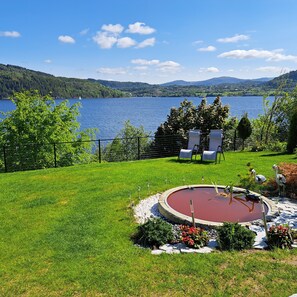 A backyard with a circular hot tub, a grassy lawn, and a view of a lake and mountains. - "Bergen Sunrise" Studio apartment on the Fjord.
Self check in; 1 free parking.  (Breistein)