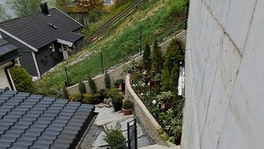 A residential staircase with a concrete wall on the right and a metal fence on the left.