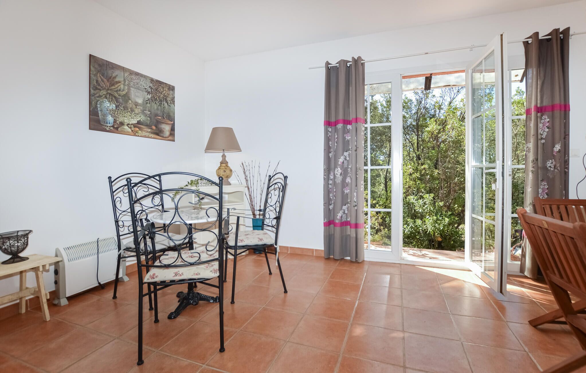 Una habitación con una mesa de comedor, sillas, una lámpara y un cuadro en la pared.