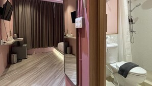 A modern bathroom with a shower, toilet, and sink.