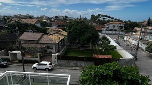 A residential area with houses, a white car, and a clear sky.
