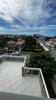 Zona residencial con casas, un coche blanco y cielo despejado.