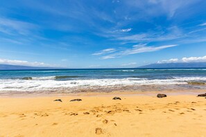 A beach with clear skies, waves, and footprints in the sand. - Direct oceanfront Studio in Kaanapali, Maui (Lahaina)