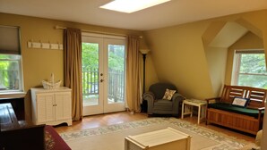 Una sala de estar acogedora con un piano, un sofá, un sillón y una mesita.