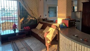 A cozy living area with a sofa, a small table, and a kitchen counter. - Villa Dr mohamed (Alexandria)