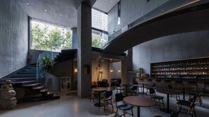Un interior moderno con una zona de bar, asientos y una escalera.