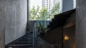 Un interior moderno con una escalera, un ventanal grande y un diseño minimalista.