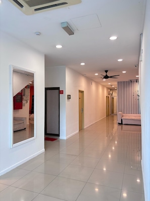 A spacious, well-lit hallway with a ceiling fan, recessed lighting, and a tiled floor. - BEAR HOTEL at NILAI (Nilai)