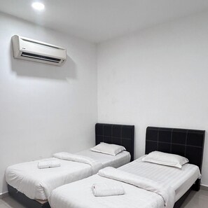 A hotel room with two single beds, white bedding, a black headboard, and a wall-mounted air conditioner. - BEAR HOTEL at NILAI (Nilai)