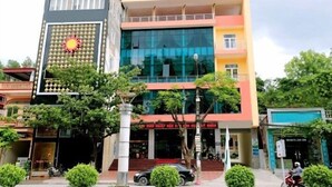 A multi-story building with a sign for the Khach San Nong Noi Hep Dien Bien Agricultural Hotel.