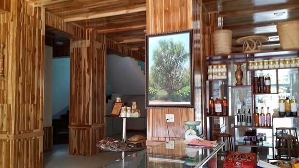 A wooden interior with a framed picture of a tree, a scale, and shelves with bottles.