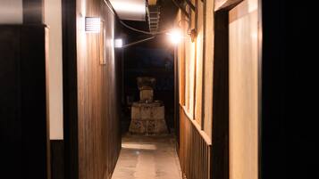 A narrow hallway with wooden walls and a stone pedestal in the center.