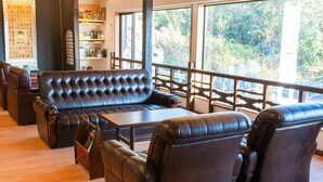 Un área de estar moderna con sofás de cuero, una mesa de centro de madera y una estantería.