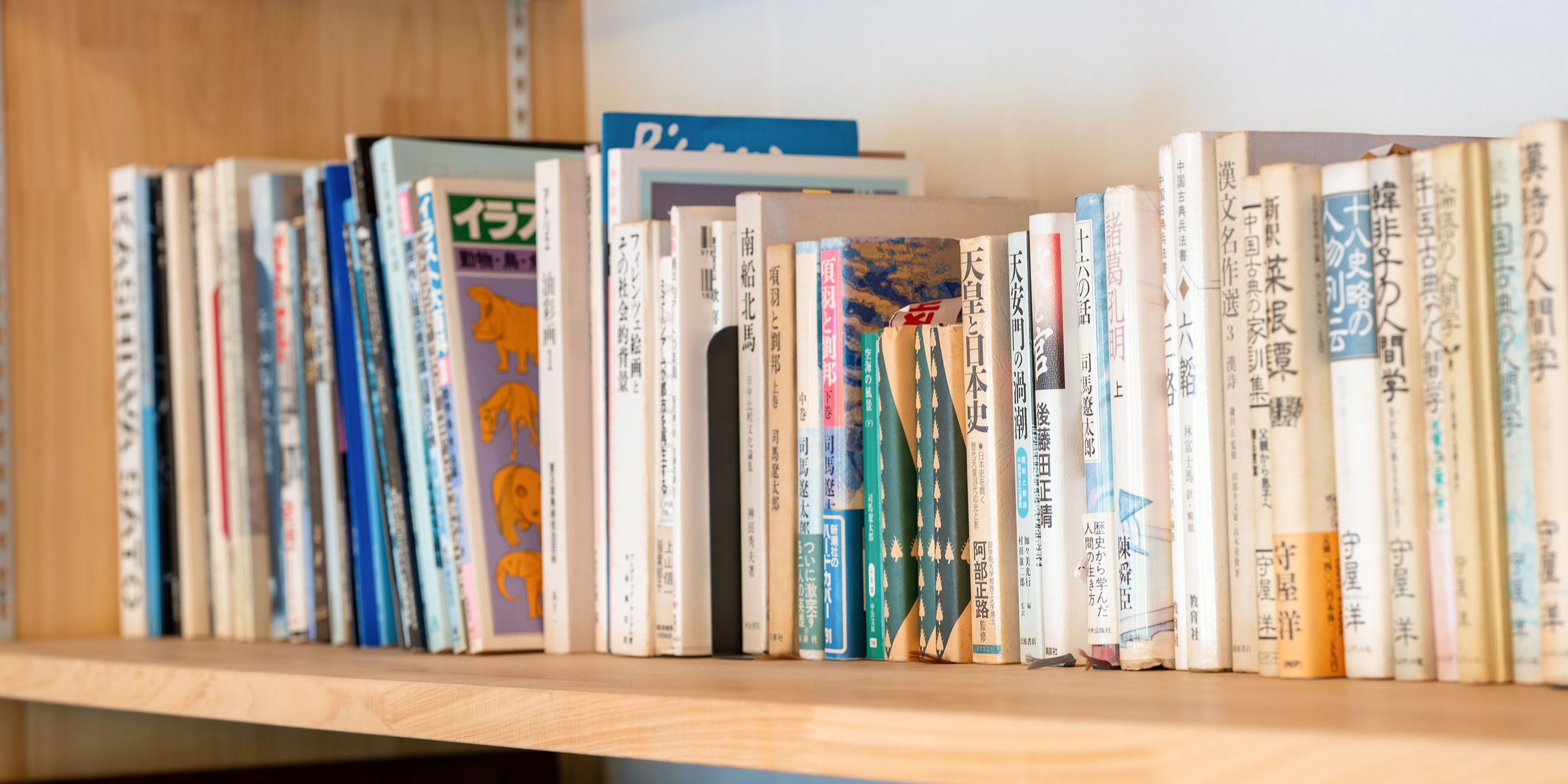 Una estantería con varios libros, algunos con texto en japonés.