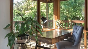 A modern room with a wooden table, a blue chair, and a potted plant. - Botanica Retreat - Village Spa & Stay (Olinda)