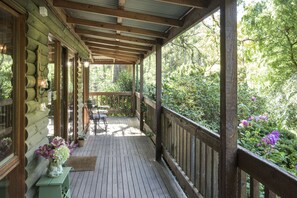 A wooden deck with a wooden railing, a bench, and a table. - Botanica Retreat - Village Spa & Stay (Olinda)