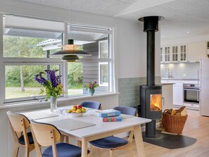 Enjoy meals in the kitchen with a central stove, dining area, and garden views through large windows.