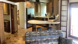 Une cuisine moderne dotée d’un îlot central, de meubles en bois et d’une cuisinière intégrée.
