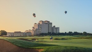 A golf course with a large building in the background. - ChampionsGate Townhome + Fast WiFi, Beautiful Kitchen. Oasis Pool & Jacuzzi. (Davenport)