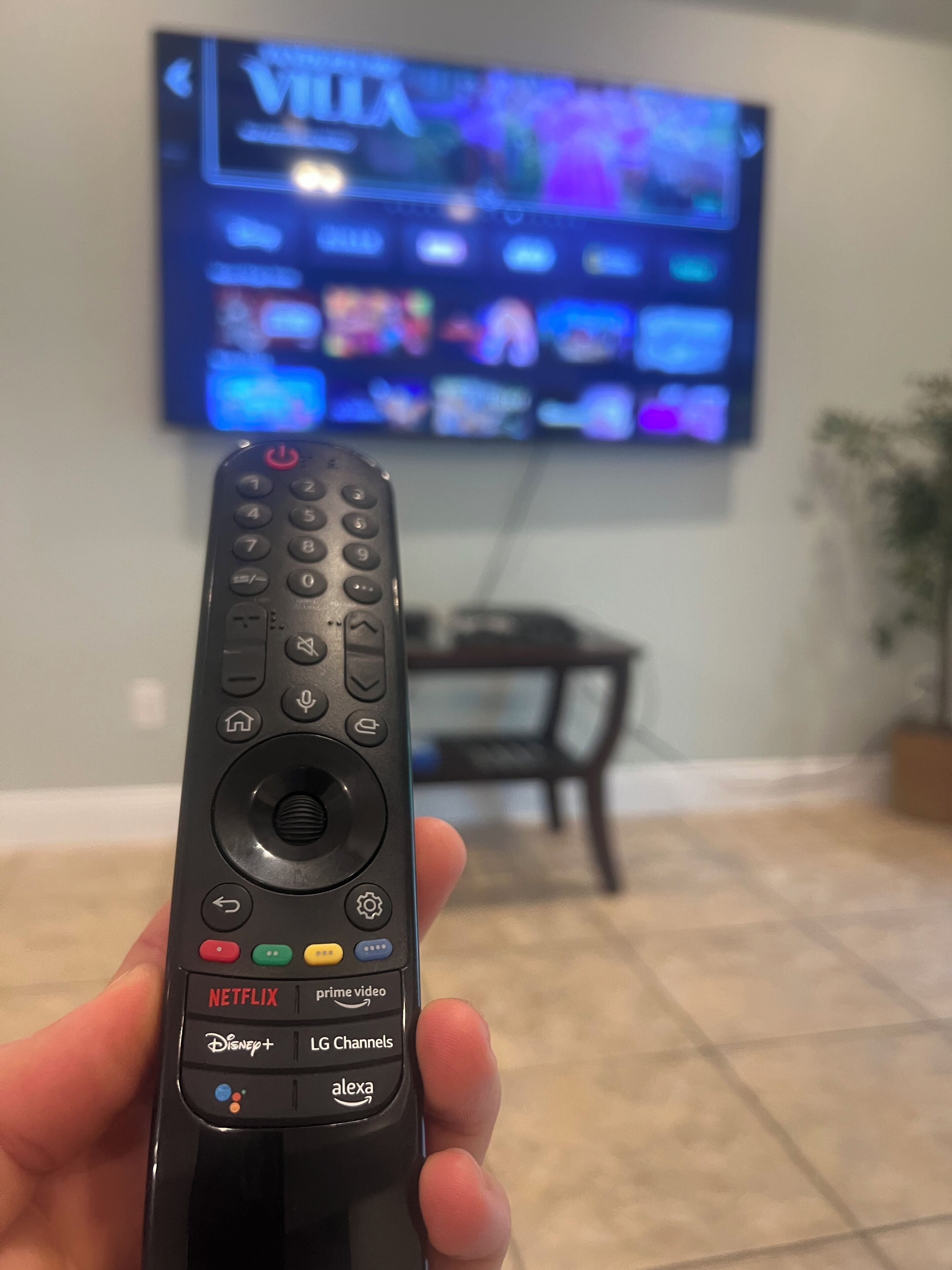 A remote control with buttons for Netflix, Disney+, LG Channels, and Alexa.