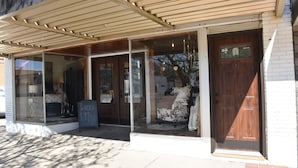 A storefront with a covered entrance, large windows, and a signboard. - Newly Renovated family-sized apartment downtown, lots of light!  (Storm Lake)