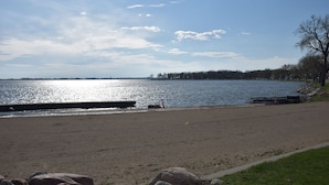 A beach with a clear sky, calm water, and a distant shoreline. - Newly Renovated family-sized apartment downtown, lots of light!  (Storm Lake)
