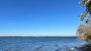 Duidelijk uitzicht op een meer met kalm water en een rotsachtige oever.
