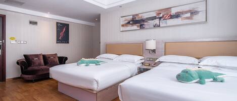 A hotel room with two beds, a sofa, and a painting on the wall.