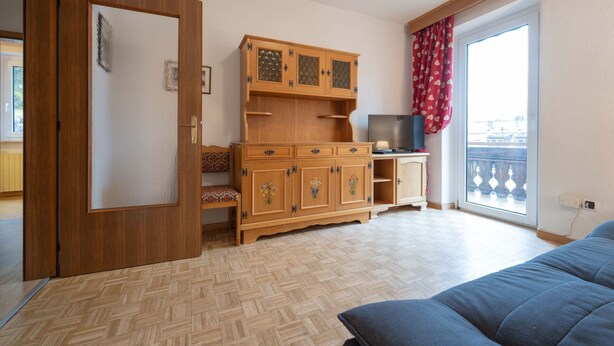 Une pièce avec un meuble en bois, une télévision et un canapé.