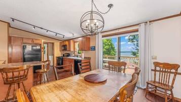 A spacious kitchen with wooden cabinets, a dining table with chairs, and a view of the outdoors.