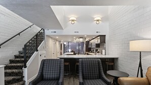 Une cuisine moderne dotée d’un îlot central, de tabourets de bar et d’une table à manger.