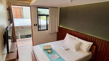 Una habitación de hotel con una cama, un escritorio y una ventana con cortinas.