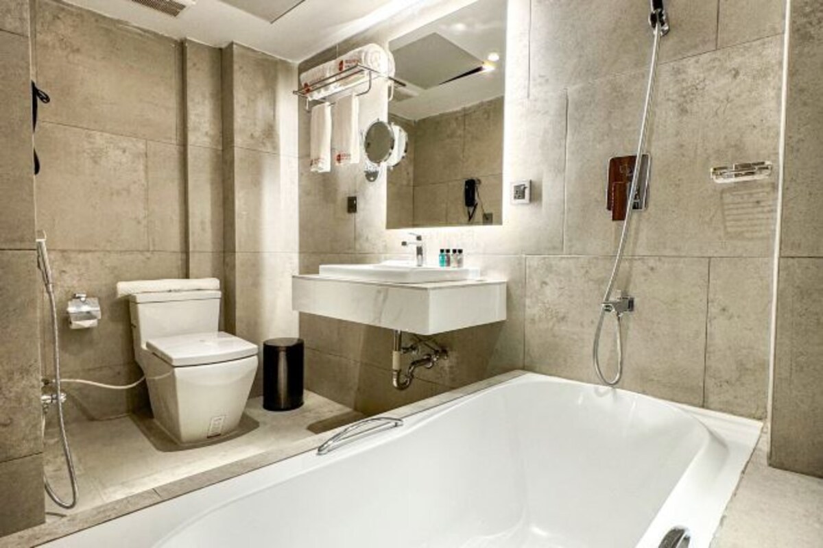 Badkamer | Een bronwaterbad, een regendouche, een haardroger, badjassen
