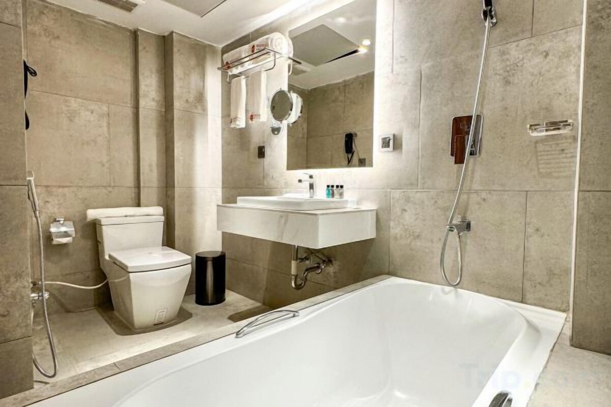 Badkamer | Een bronwaterbad, een regendouche, een haardroger, badjassen