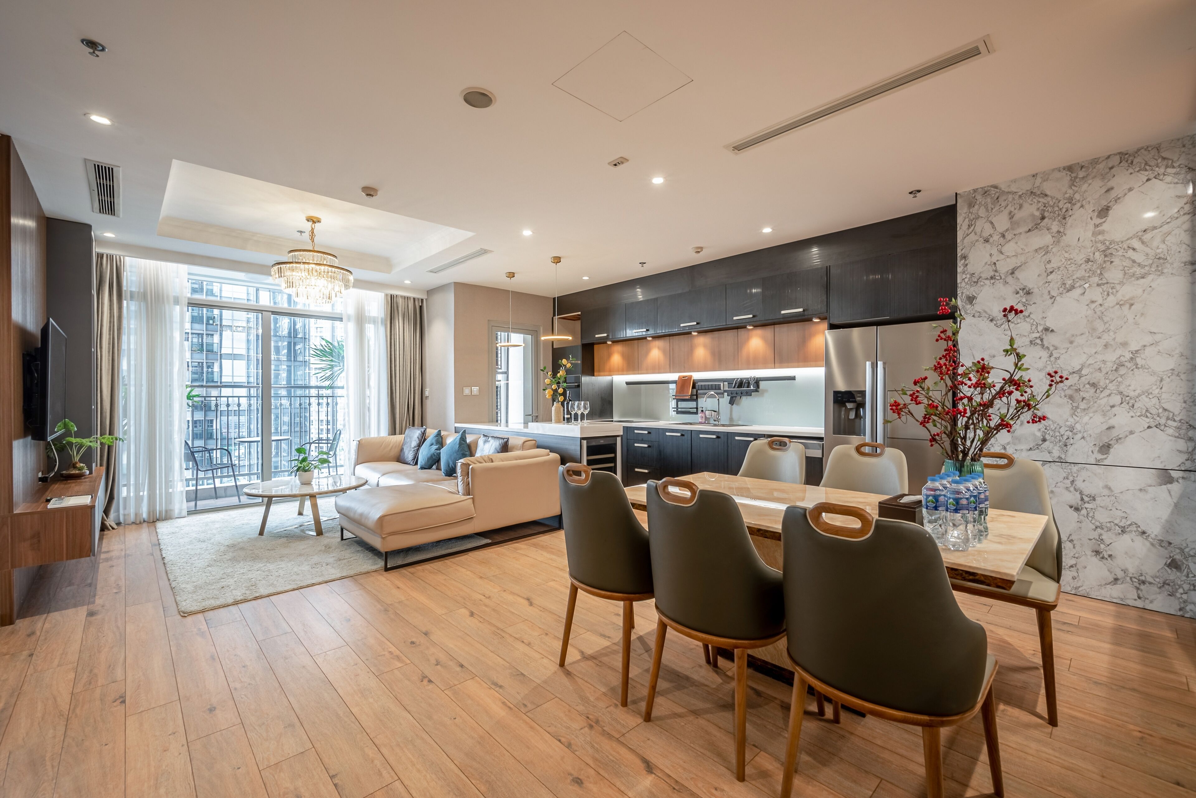 Un salon moderne comprenant un canapé, une table basse et un coin repas avec des chaises.
