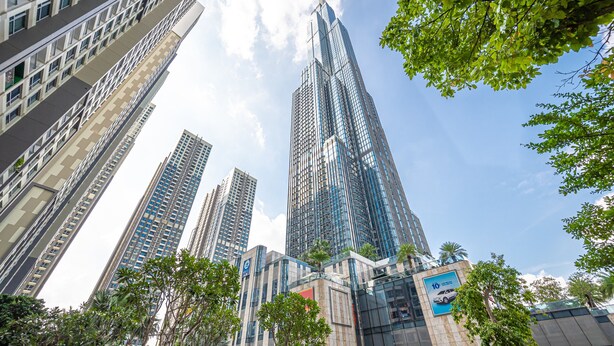 A high-rise building with a modern glass facade, surrounded by trees and other tall buildings. - The Celavie Serviced Apartment Landmark (Ho Chi Minh City)