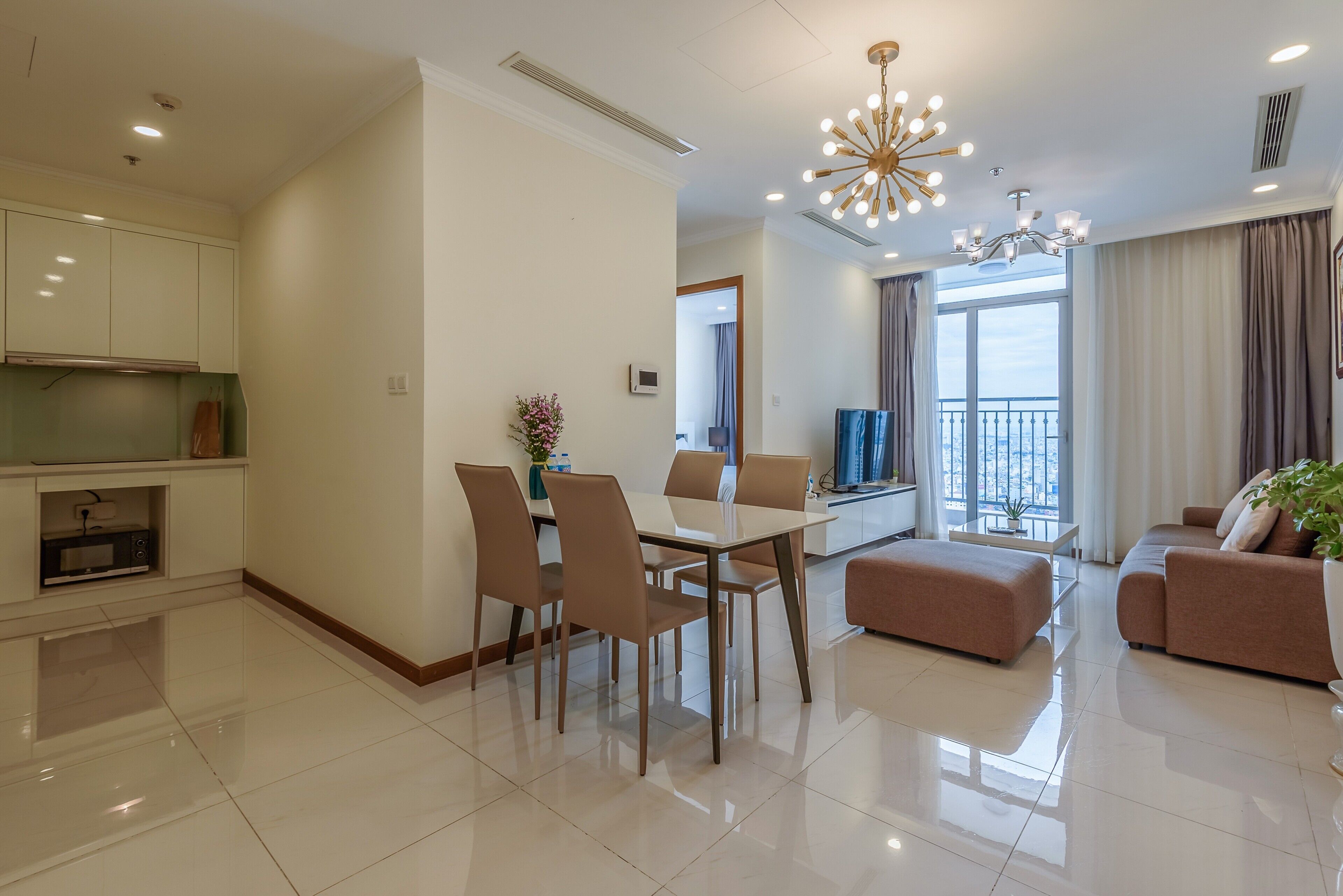 A modern living room with a dining area, a sofa set, and a large window with a view.