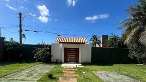 A pathway leading to a building with a tiled roof and a wooden door. - Pousada Summer Kite Cumbuco (Caucaia)